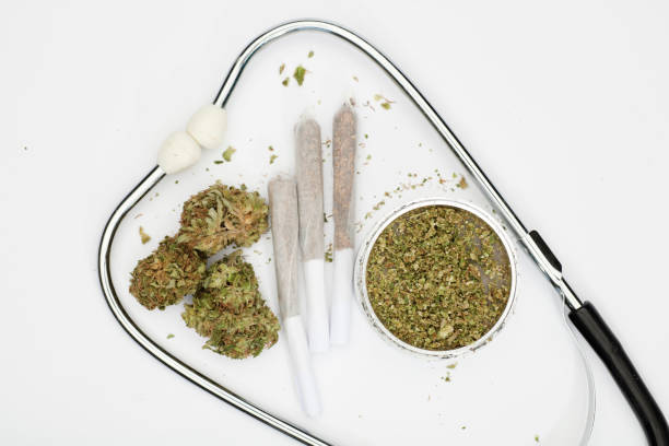 istock marijuana buds, joint, phonendoscope, grinder with white background, space for text. 1372219382