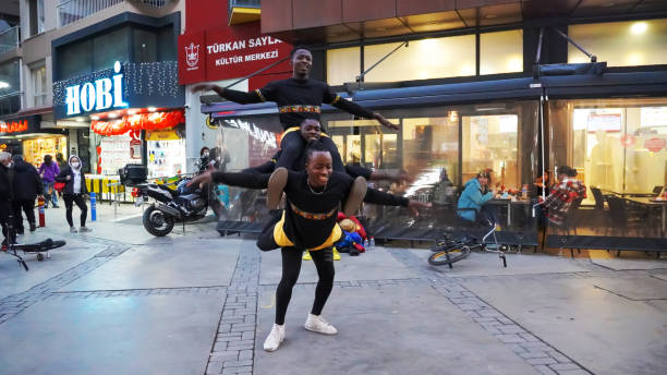 Two young Caucasian athlete women practicing acroyoga in public garage.