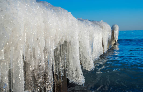 Empty seashore with  the pier in ice white ocean on a bright day