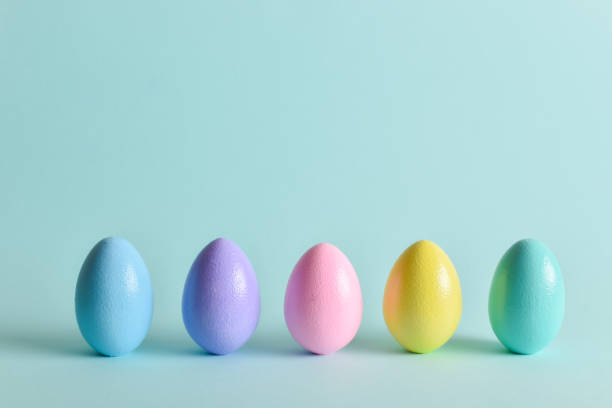 istock Painted eggs of delicate tones stand on a pale blue background. 1372223629
