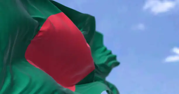 Photo of Detail of the national flag of Bangladesh waving in the wind on a clear day