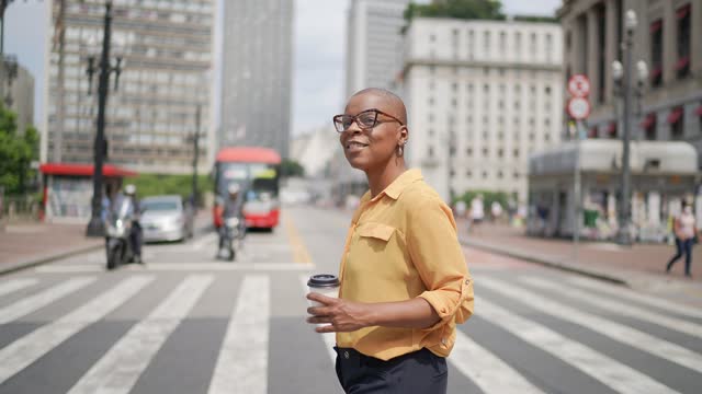 Mature businesswoman crossing the street and looking away at city