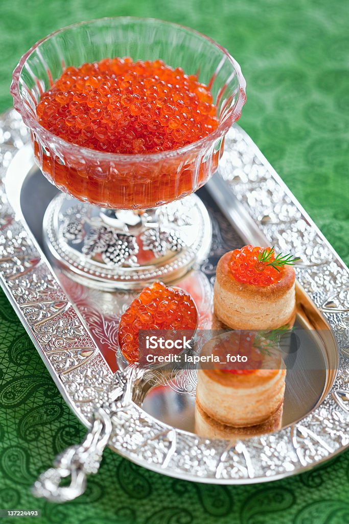 Red caviar Bowl and spoon with red caviar and vol-au-vent with red caviar, selective focus Appetizer Stock Photo