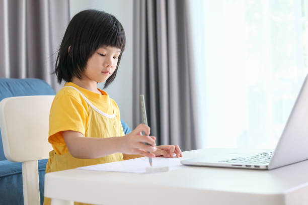 istock little asian girl student study online using laptop computer at home 1372252607
