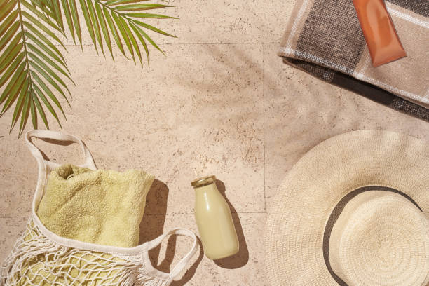 Summer sunny beach concept flat lay.Hat, string bag with towel and bottle, palm leaves, accessories. Summer sunny beach concept flat lay.Hat, string bag with towel and bottle, palm leaves, accessories. High quality photo beach bag stock pictures, royalty-free photos & images