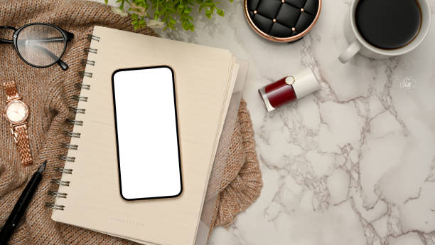 istock Female office desk workspace with smartphone mockup on marble background. 1372259828