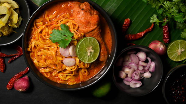 istock Khao Soi Kai with fresh vegetables side dish on banana leaf in background. 1372259866