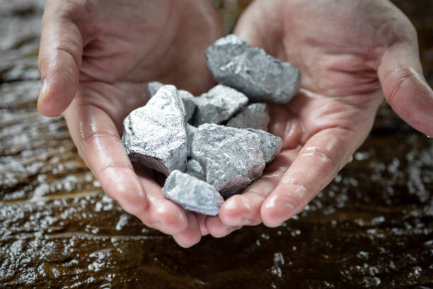 la mano del hombre mojado sostenía plata, platino o minerales de tierras raras. - metal ore mineral stone block fotografías e imágenes de stock