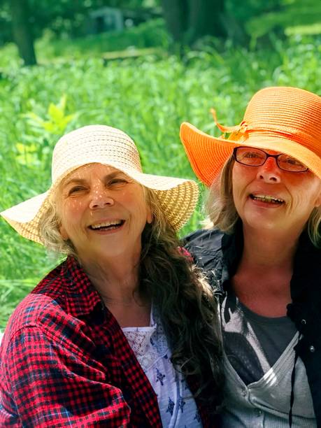 istock Straw hat senior sisters, laughing and playing in the Meadow. 1372269507
