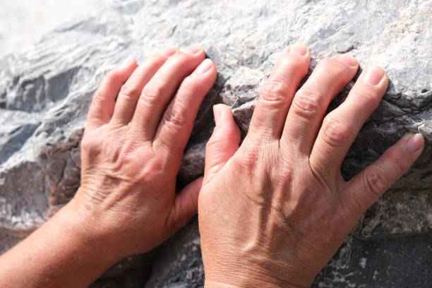 close up hände der älteren frau auf steinhintergrund. arthritis, osteoporose, rheuma - thumb stones stock-fotos und bilder