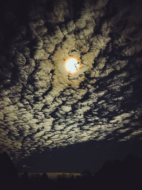 Night sky with clouds and glowing moon. stock photo
