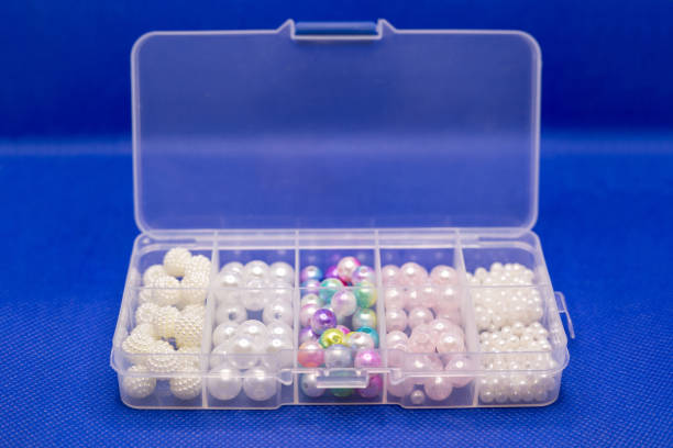 istock Transparent plastic container with beads and beads of different sizes, blue background 1372273965