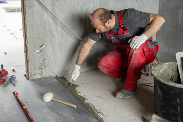 istock Man applying tile adhesive on the floor 1372276847