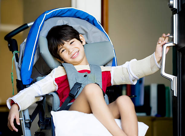 Handsome disabled boy in wheelchair opening door stock photo