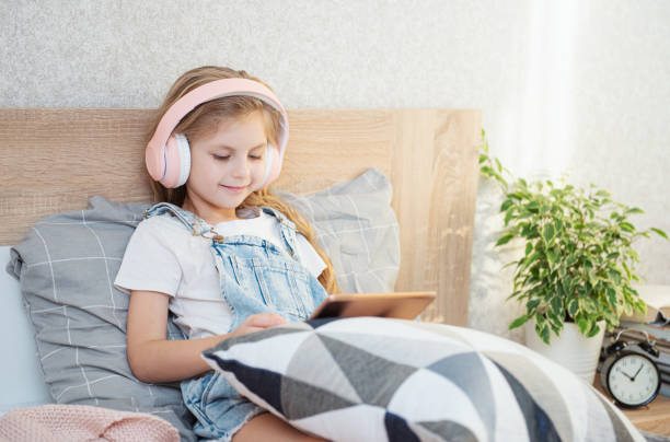 istock Cute Little girl  using tablet at home 1372280668