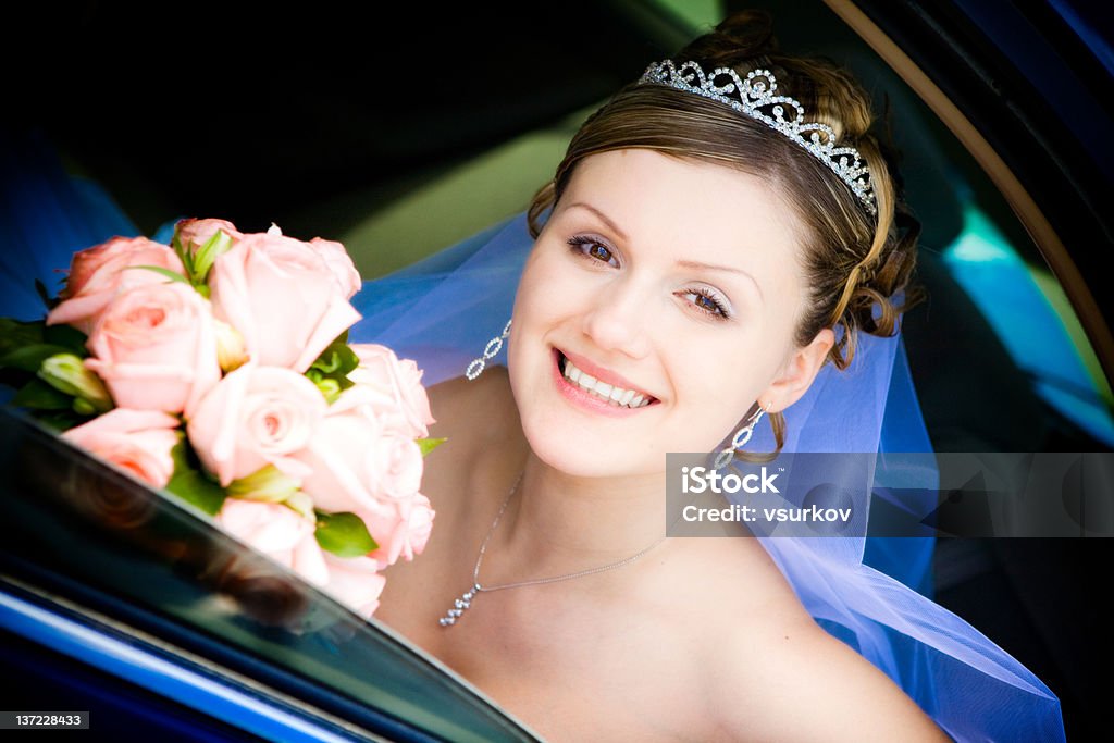portrait of bride in the wedding car happy bride with flower bouquet siting in the car Adult Stock Photo