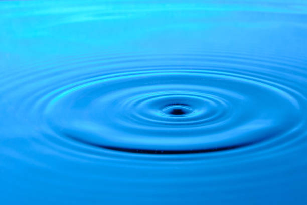 istock Bright blue background with diverging circles from dropped drop on surface water. 1372284609