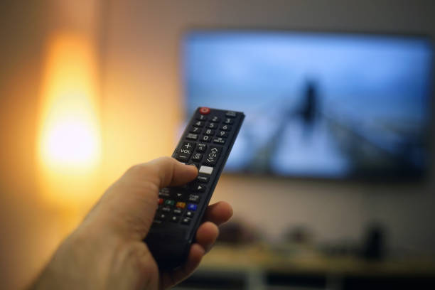 istock hand holding a tv remote 1372284653