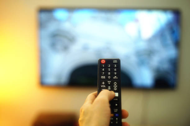 istock hand holding a tv remote 1372284666