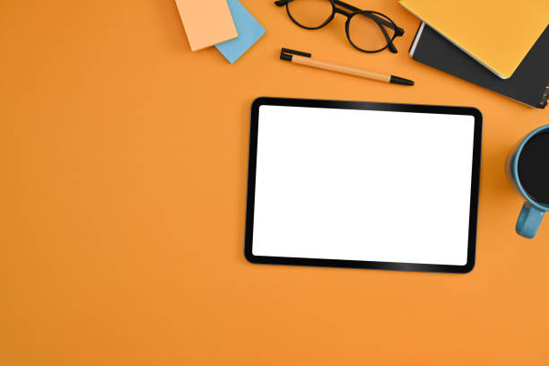 istock Mockup digital tablet, glasses, coffee cup and notebooks on yellow background. Flat lay. 1372285776