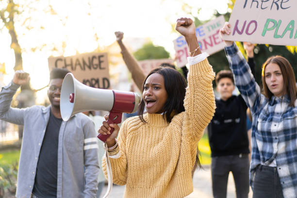 istock A young woman using a megaphone to lead a rally about climate change 1372286416