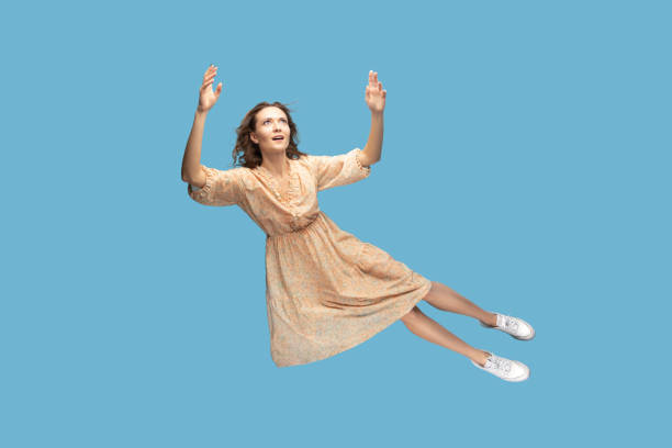 istock woman levitating flying in mid-air, looking up with dreamy relaxed expression 1372288142