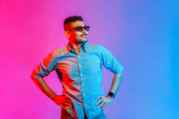 istock Man in glasses standing with hands on hips, looking away with positive and optimistic expression. 1372288338