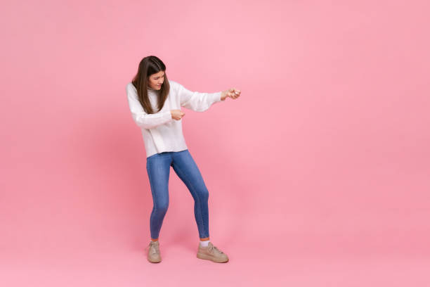 full length portrait of girl pulling invisible rope with effort, using all strength to achieve goal. - imagination fantasy invisible women imagens e fotografias de stock