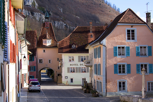 Beautiful historic houses with colorful facades at the little medieval town of St-Ursanne, Canton Jura, on a winter morning. Photo taken February 7th, 2022, Saint-Ursanne, Switzerland.