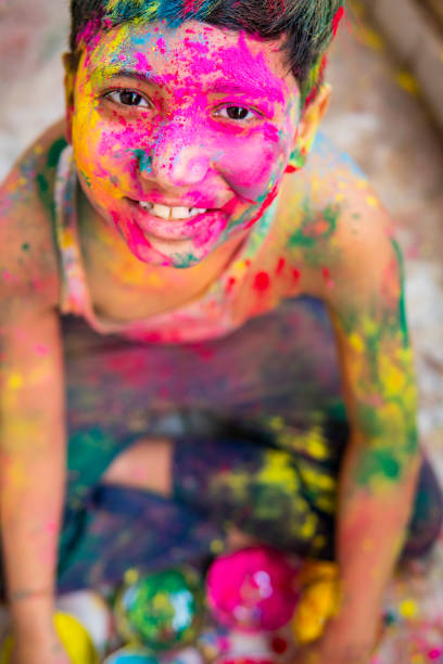 high angle image of happy boy playing color powders and celebrating the holi festival. - facial expression child asia asian and indian ethnicities imagens e fotografias de stock
