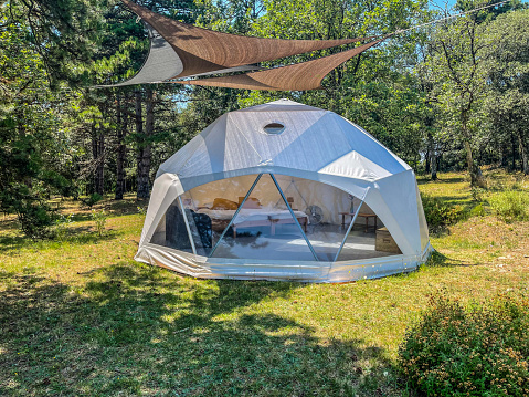 Glamping dome tent in a forest and field setting