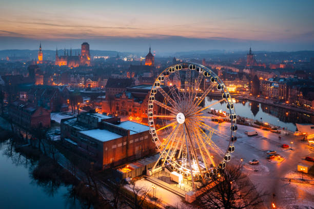 Beautiful sunset over the Gdansk city with illuminated ferris wheel. stock photo