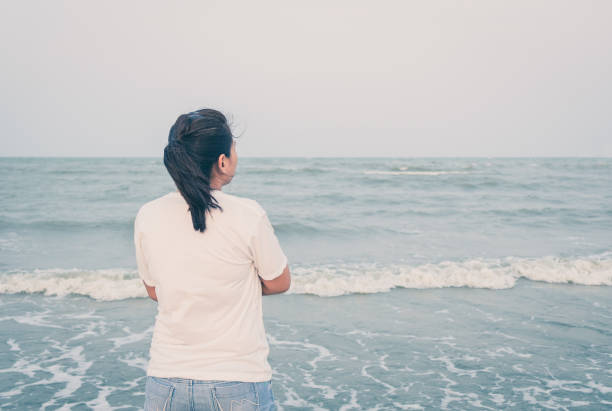 istock Woman lonely on the beach 1372298821