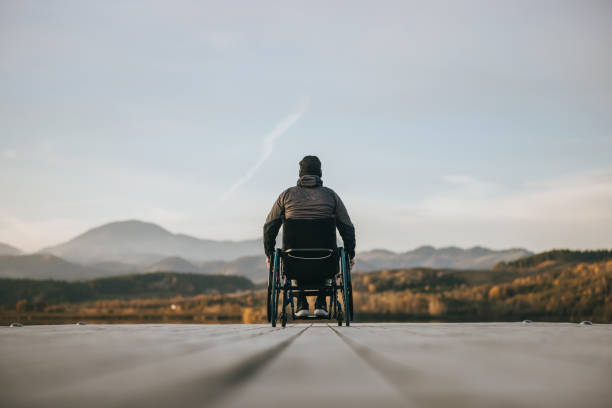 istock Paraplegic in wheelchair on pier at sunset 1372302289
