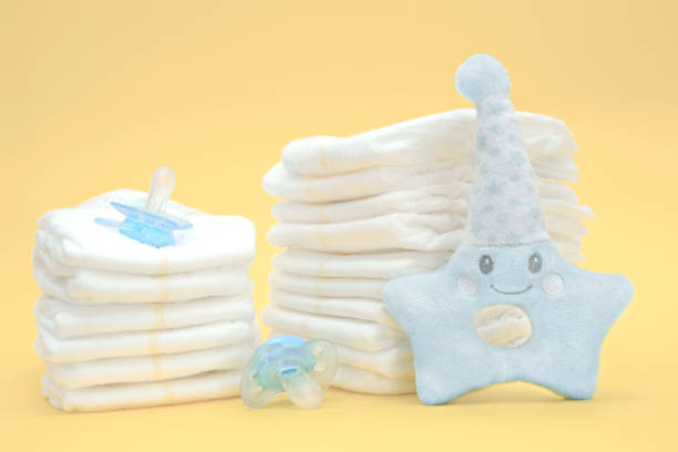 istock Stack of baby disposable diapers,two pacifiers and a plush toy for newborns 1372302299