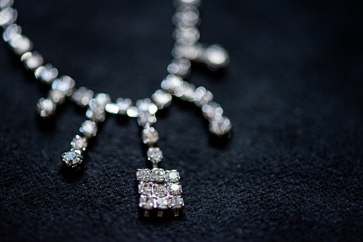 Close-up of diamond necklace on a black background.