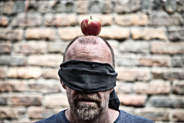 Blind fold on man with apple on head Blind fold on man with apple on head firing squad stock pictures, royalty-free photos & images