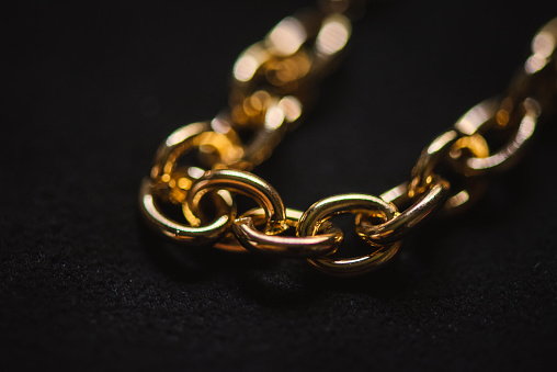 Close-up of gold bracelet chains on a black background