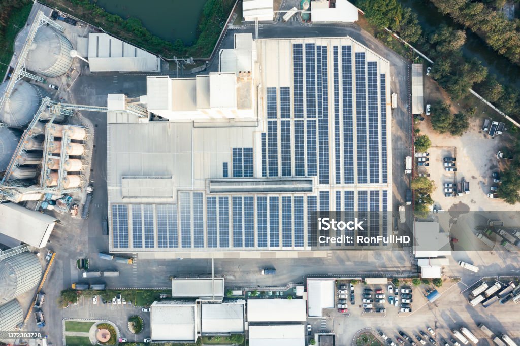 Eco building or factory in aerial view. Eco building or factory in aerial view or top view consist of solar cell or photovoltaic cell in panel on top of roof. System technology to generate electrical power or direct current electricity by light or sunlight. That is green, clean and renewable energy for future. Solar Energy Stock Photo