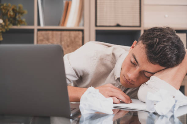 istock Close up business man put head on folded hands sleeping at workplace. Overloaded office employee tired of routine monotony paperwork. Unmotivated worker, insomnia and chronic fatigue syndrome concept 1372304671