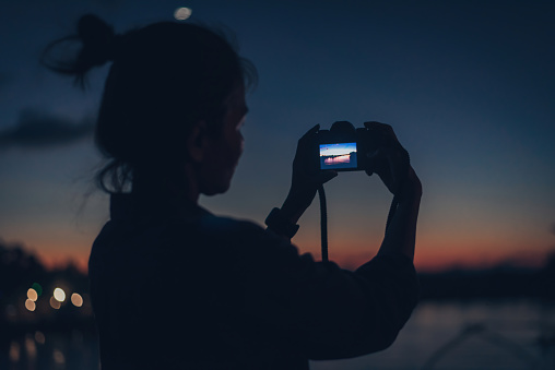 young woman using a camera in low light