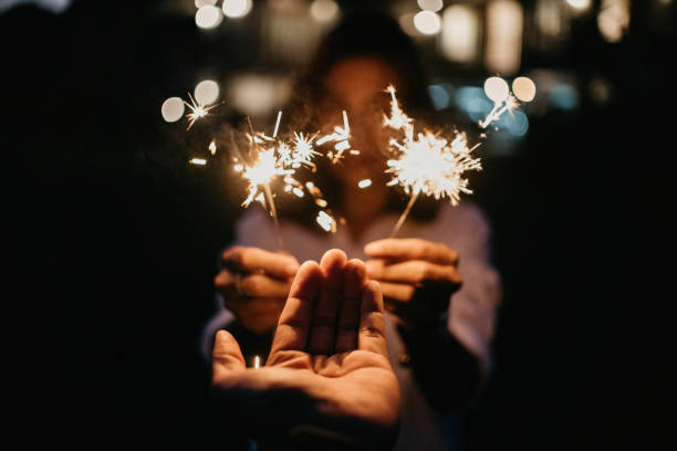 istock human hand and fireworks that is a cold light rod pointed and blurred background woman with bright bokeh 1372306363