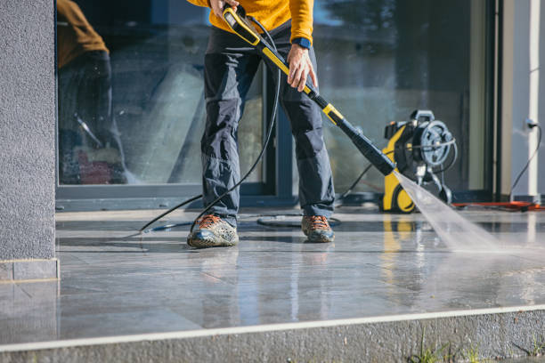 Man cleaning the terrace with high pressure cleaner stock photo