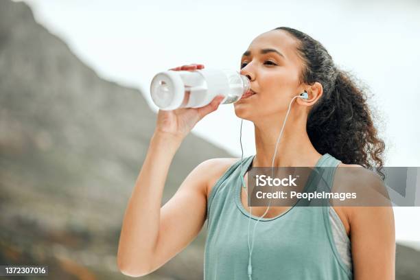 Shot Of A Young Woman Taking A Break From Working Out To Drink Water Stock Photo - Download Image Now