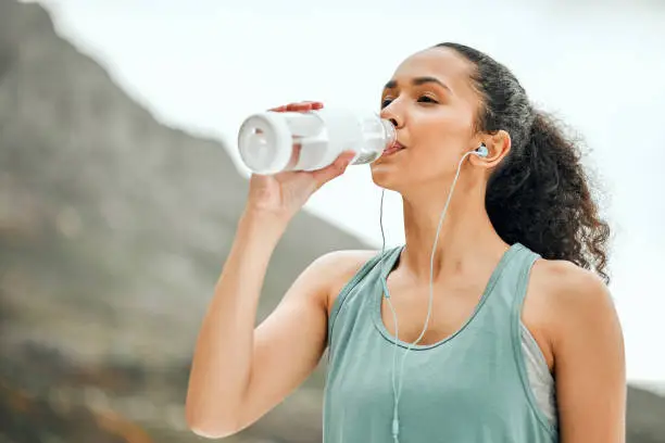 Photo of Shot of a young woman taking a break from working out to drink water