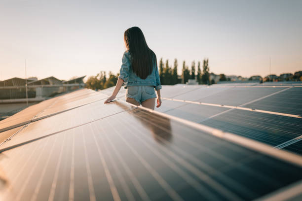 istock Young woman touching solar energy panels at solar panels 1372307783