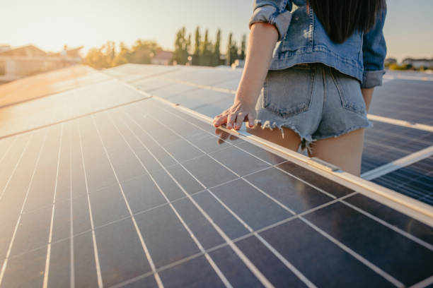 mani di donna che toccano i pannelli di energia solare alla centrale elettrica - denim shorts foto e immagini stock