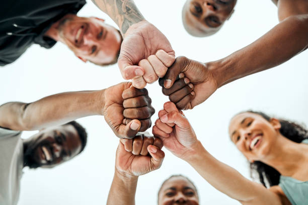 shot of a group of friends fist bumping one another before a workout - team sport imagens e fotografias de stock