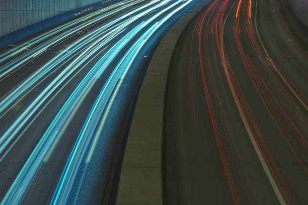Long exposure photography. Defocused photography of Moscow motorway in night time. Big traffic. Street is filled by cars. Blurred motion of cars. Frontal and back, rear view. White and red lights