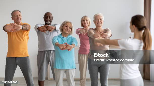 Sporty Elderly People Having Fitness Class Training With Instructor Stock Photo - Download Image Now